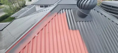 Metal roof repaint — primer and charcoal topcoat coats applied in Melbourne