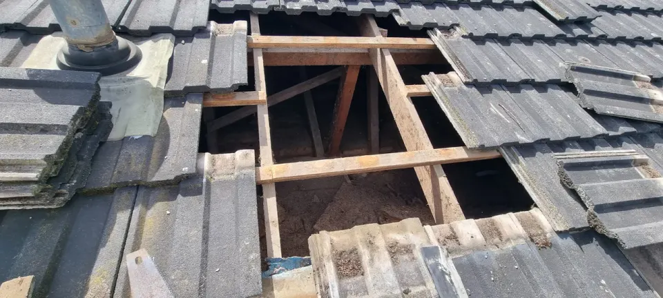 Tiles lifted back to the battens and rafters while a section of roof is repaired