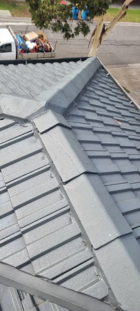 Ridge cap re-pointing on a charcoal tiled roof in Melbourne