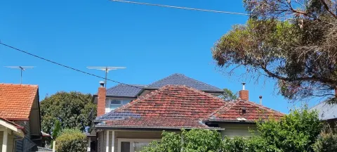 Before: a Melbourne home from the street with a faded orange terracotta tiled roof