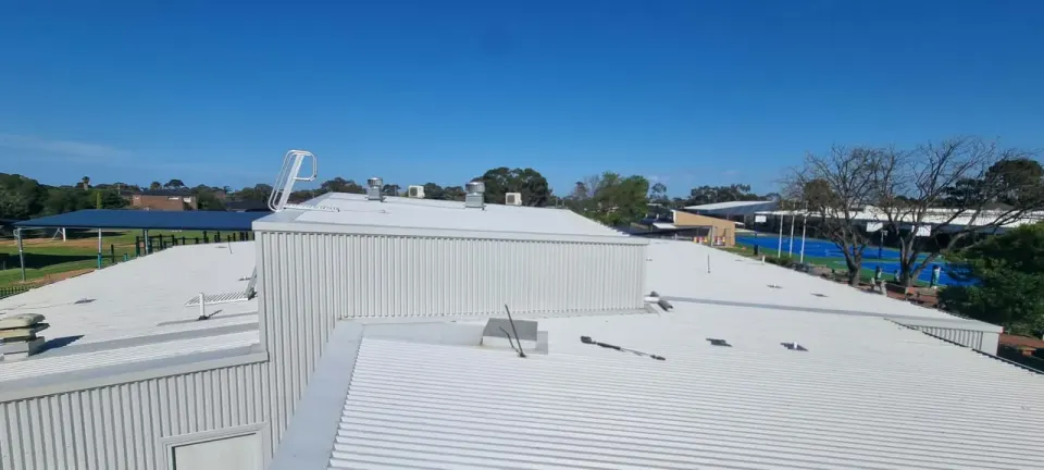 Large commercial metal roof after a high-pressure clean, finished in white, on a Melbourne commercial building