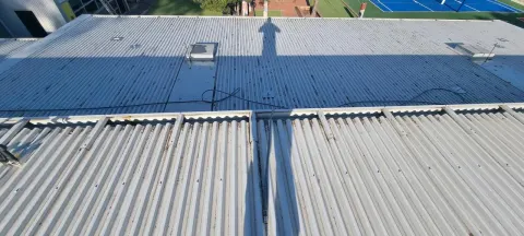 Weathered commercial metal roof sheeting being cleaned down in Melbourne