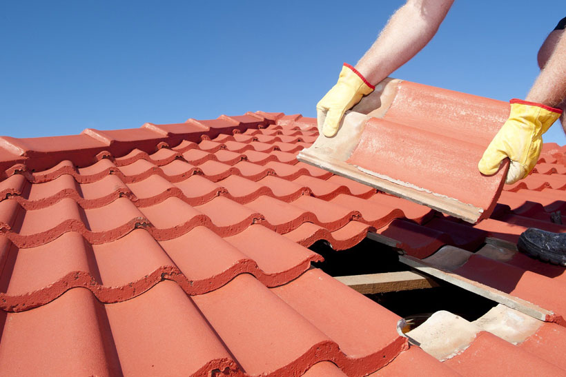 Person putting tiles on a roof